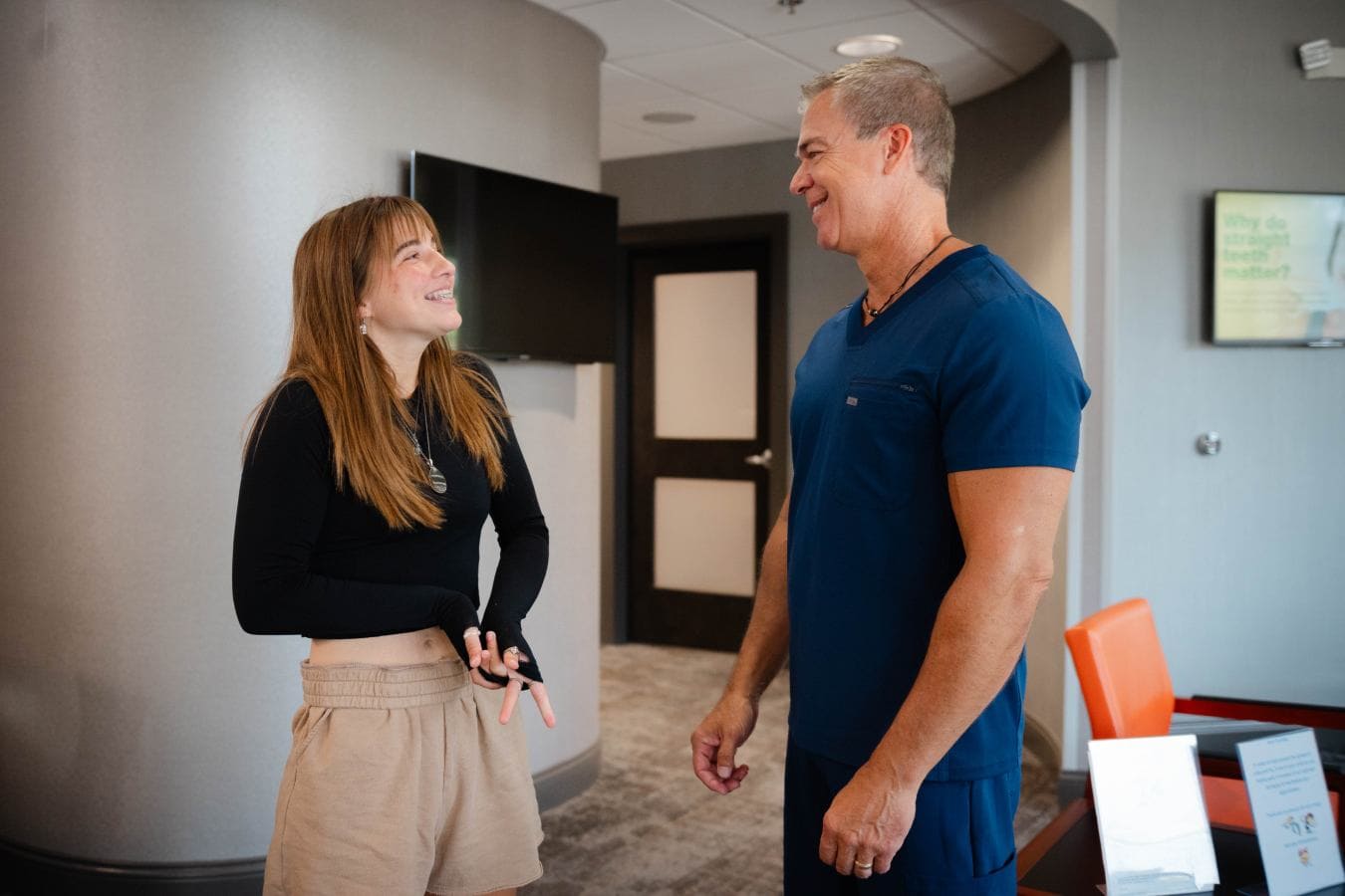 Happy young girl talking with doctor